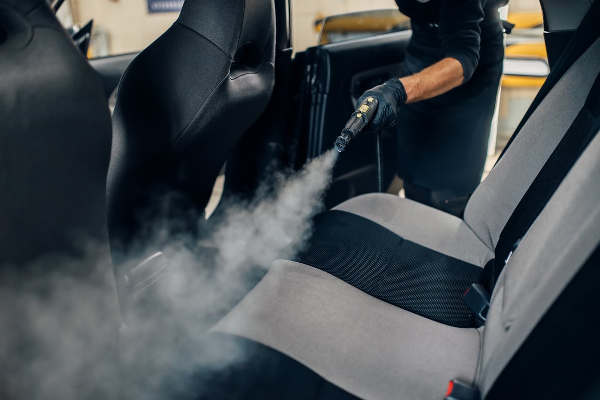 Carwash, Worker Cleans Seats with Steam Cleaner